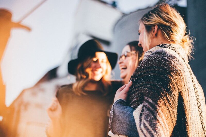 Drei Frauen lachen über einen Witz.