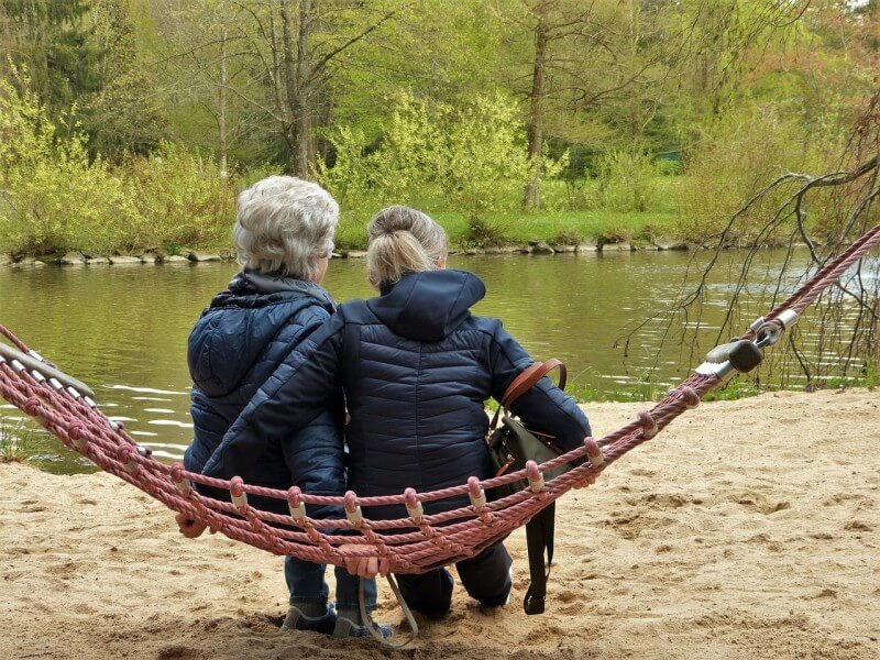 Mutter und Tochter sitzen an einem See.